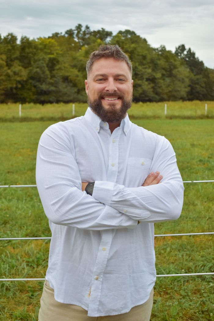 A man in a suit and tie is smiling for the camera.