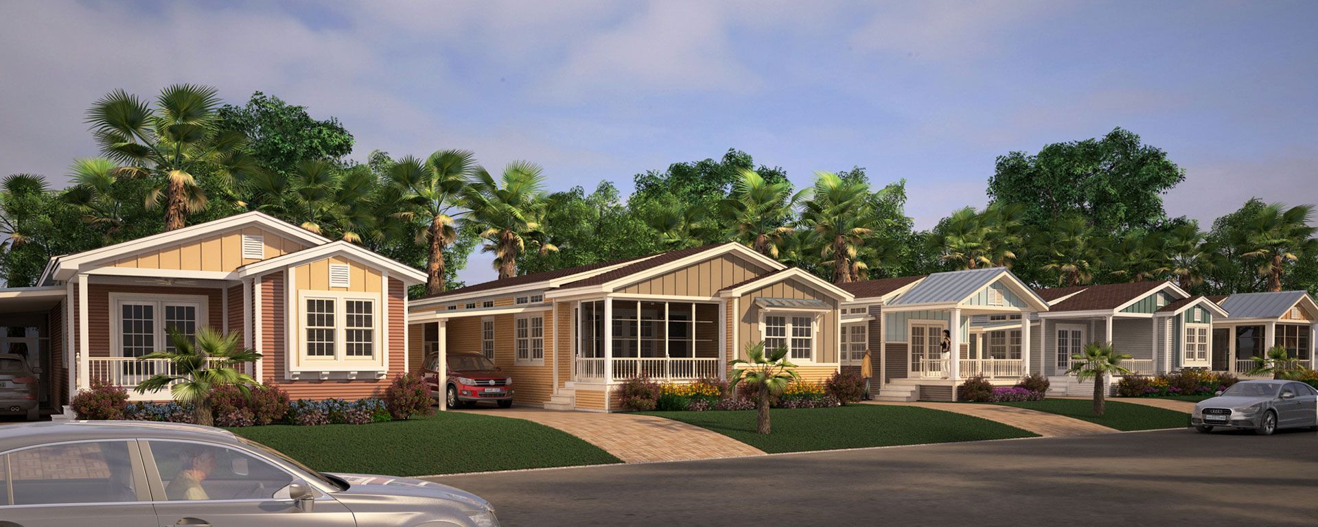 Row of colorful bungalows with porches and surrounding greenery on a sunny day; cars parked in front.