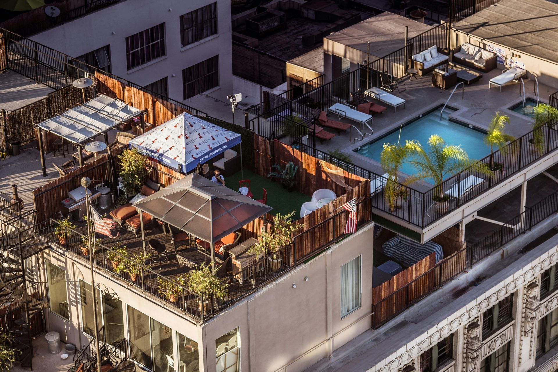 An aerial view of a building with a swimming pool on the roof.
