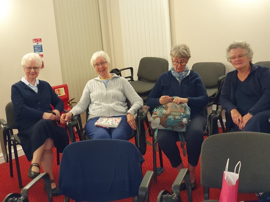 a group of women are sitting in chairs in a room .