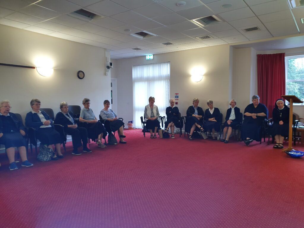 a group of women are sitting in a circle in a room .