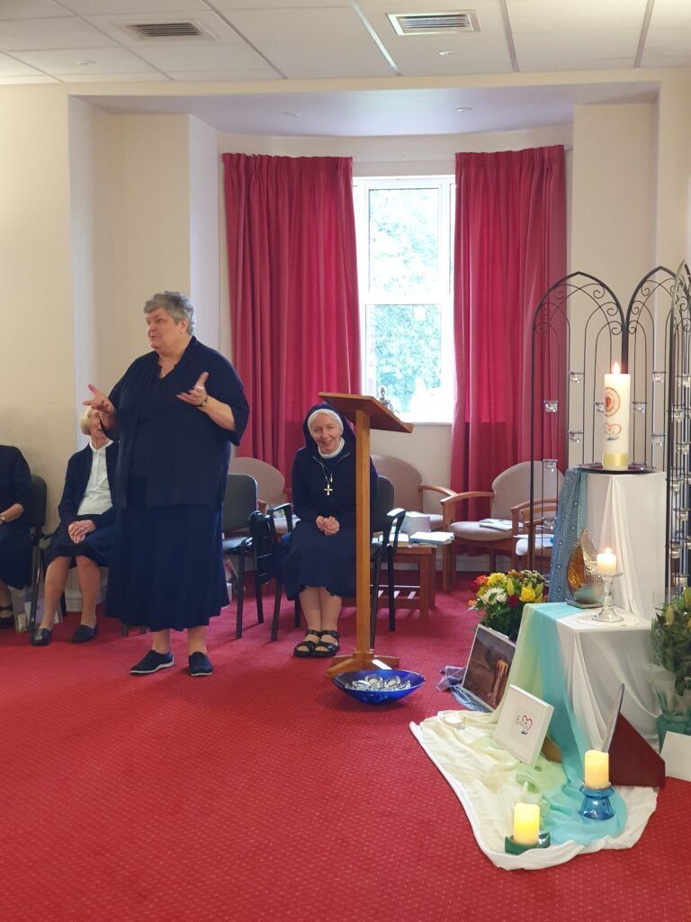 a woman is standing at a podium in a room with people sitting in chairs .