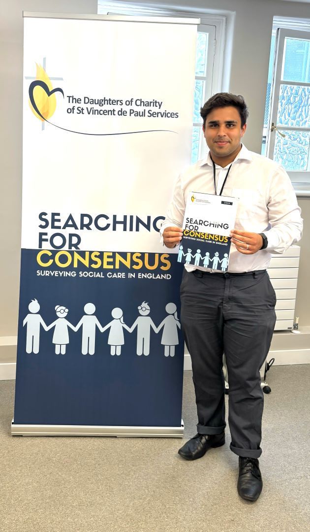 A man is standing in front of a sign that says searching for consent