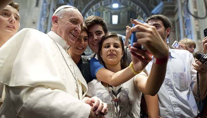 A group of people are taking a selfie with Pope Francis
