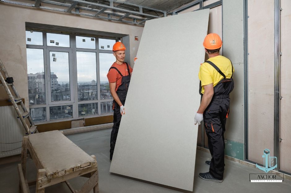 Team of sheetrock hanging contractors in Oakville, Ontario preparing to install drywall in a room.