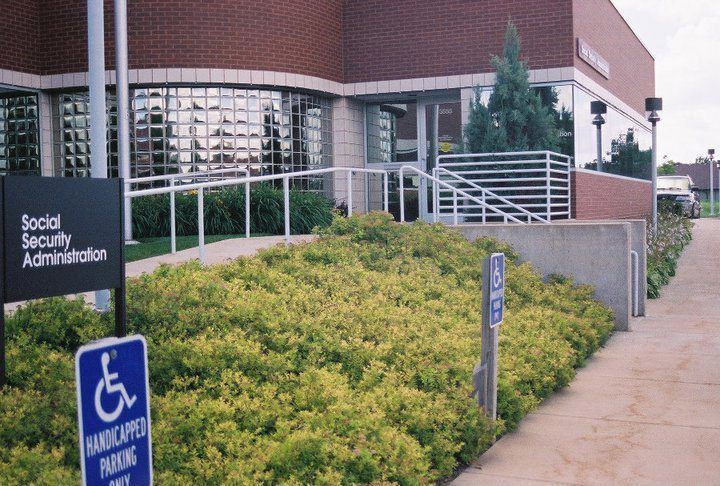 Social Security Administration building entrance with wheelchair-accessible parking sign and ramp