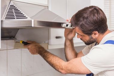 Man fixing a hood range