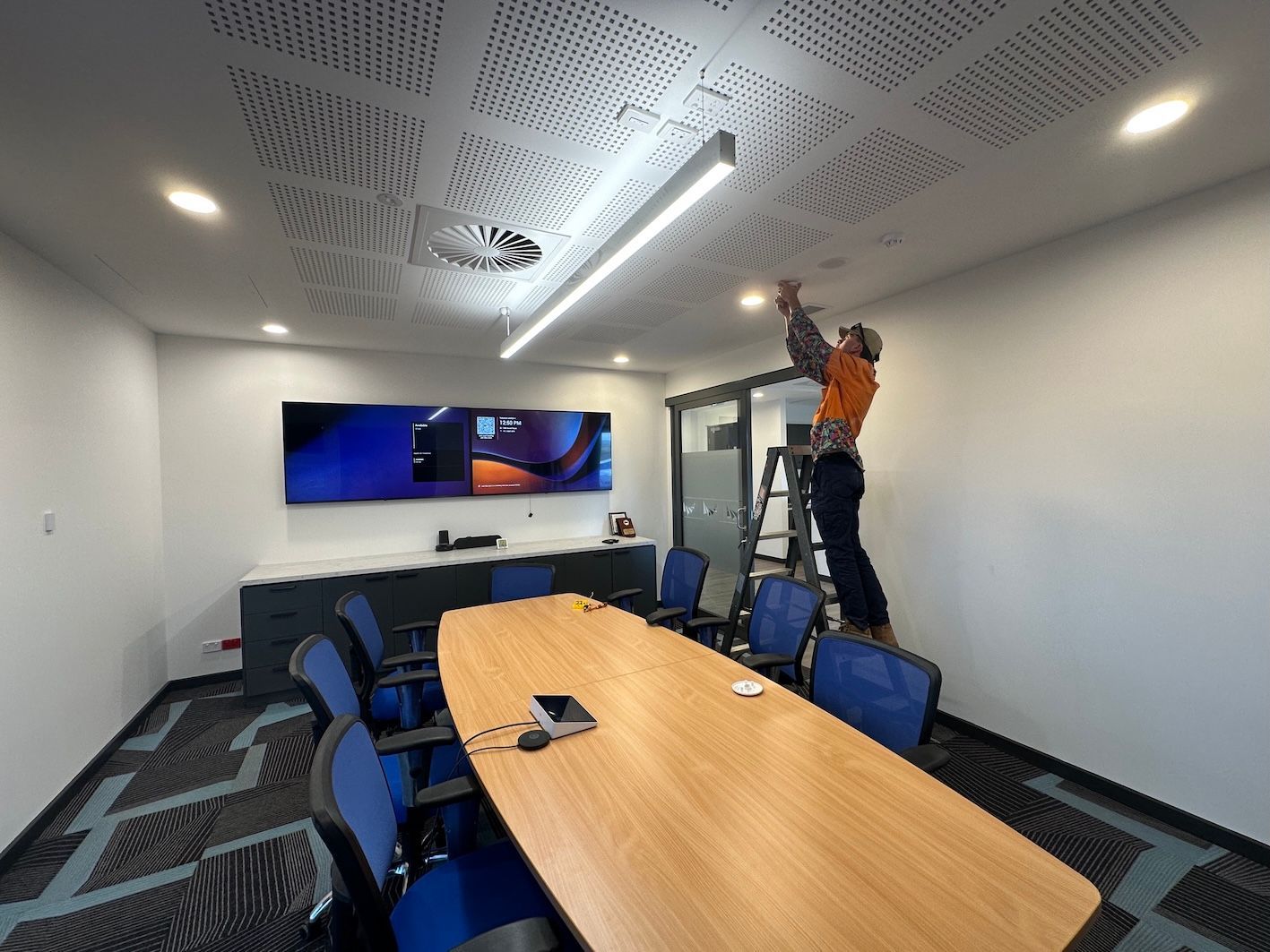 A Conference Room With a Technician Installing Video Conferencing — Frontier Connect in Newtown, QLD 