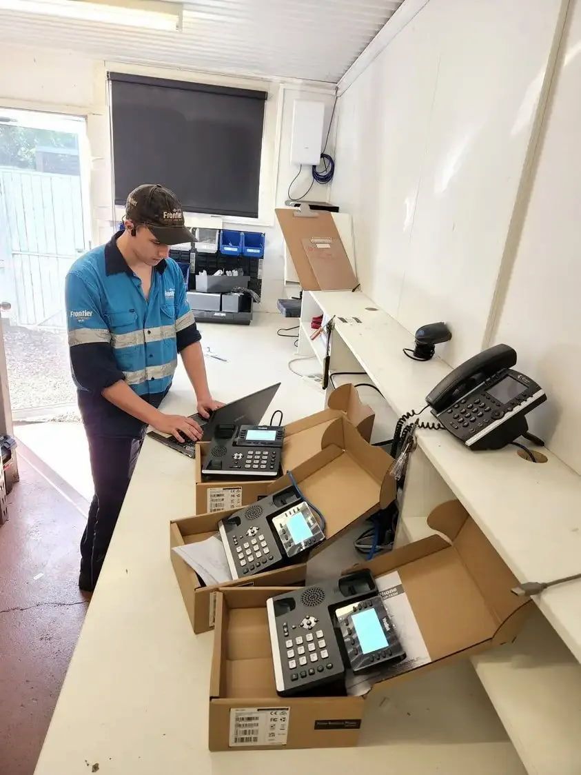 A Man in a Yellow Safety Vest is Working on a Computer — Frontier Connect in Kingaroy, QLD