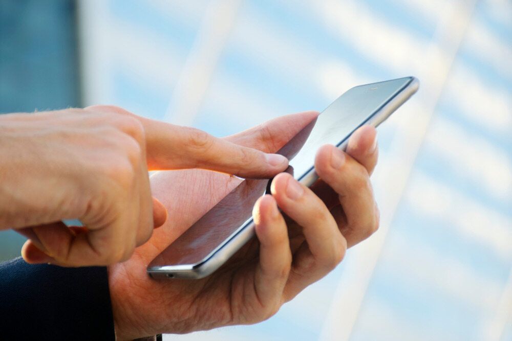 A Person is Using a Smart Phone With Their Finger on the Screen — Frontier Connect in Dalby, QLD