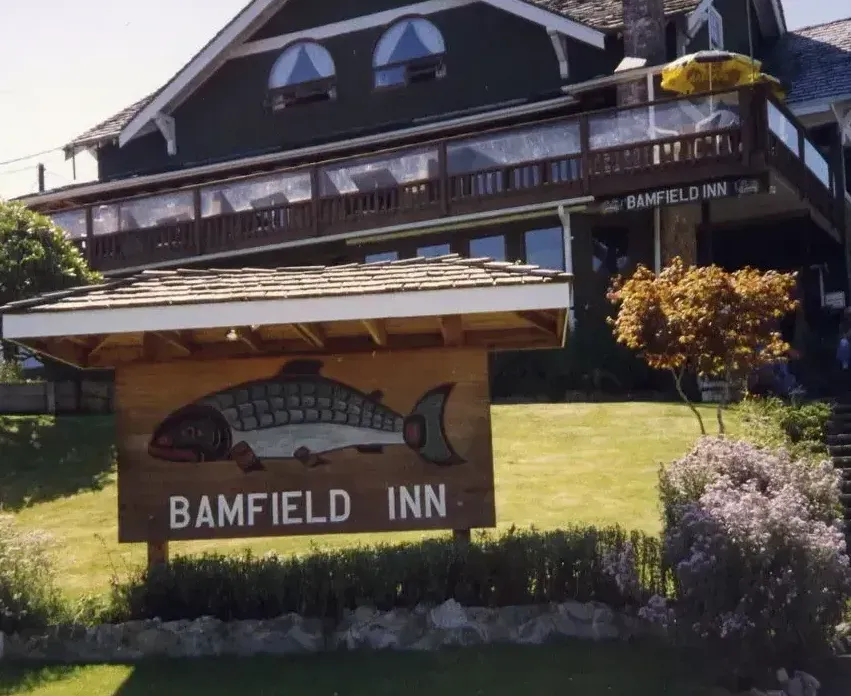 A wooden sign with a painted fish reading 