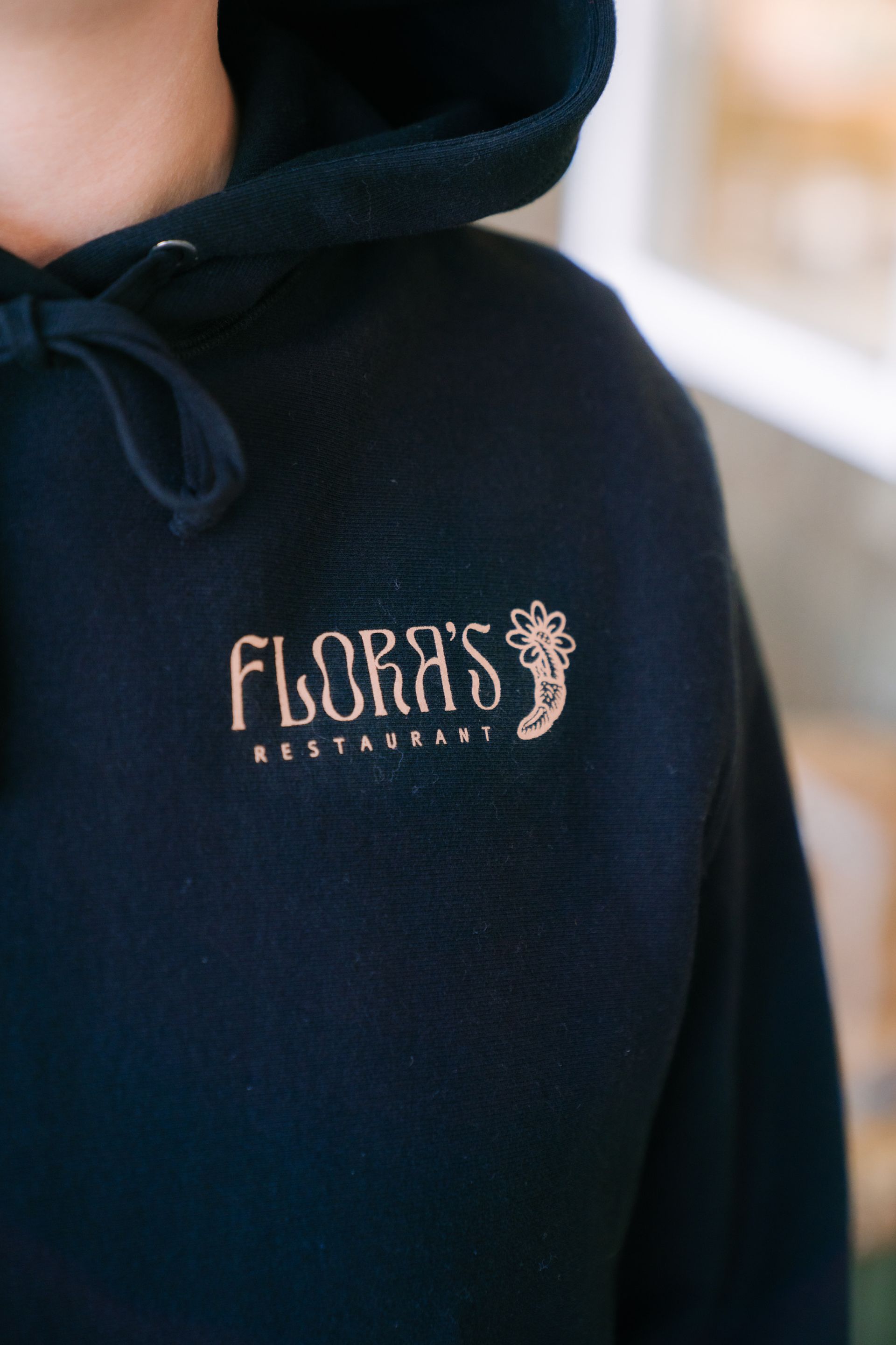 A close-up of a black hoodie featuring the gold-colored text 