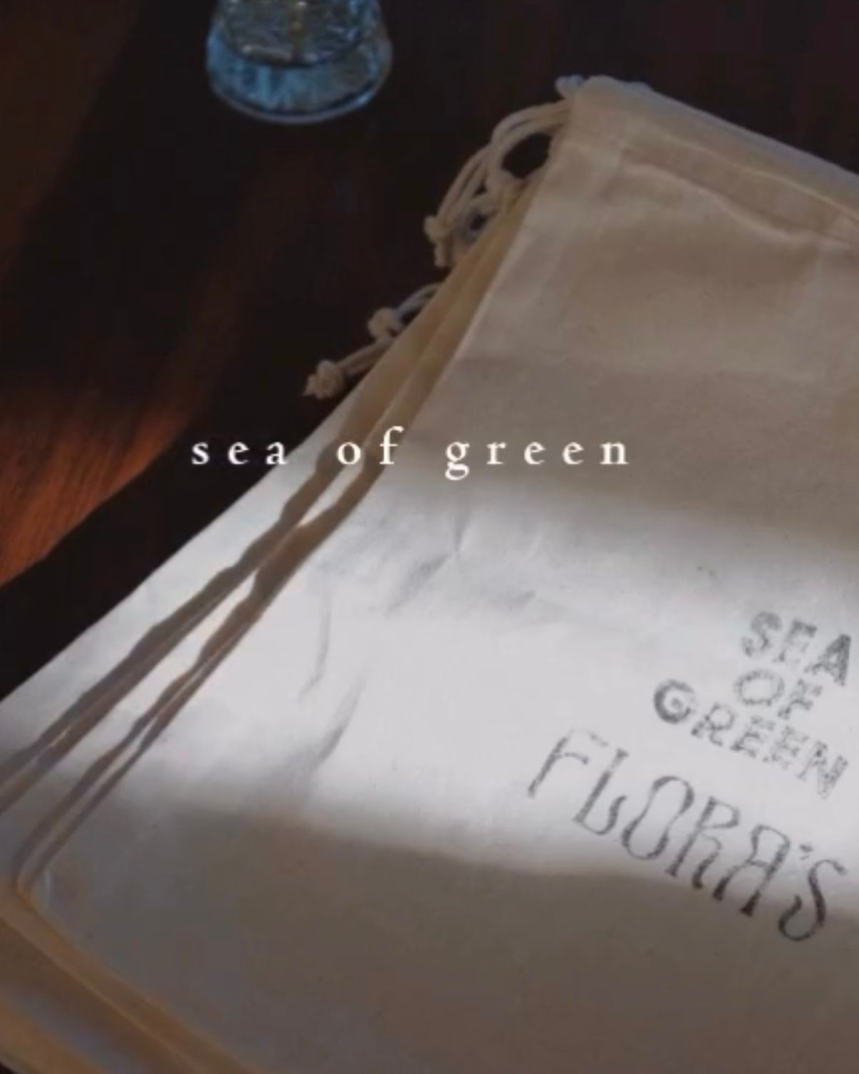 A cream-colored drawstring canvas bag with the text 