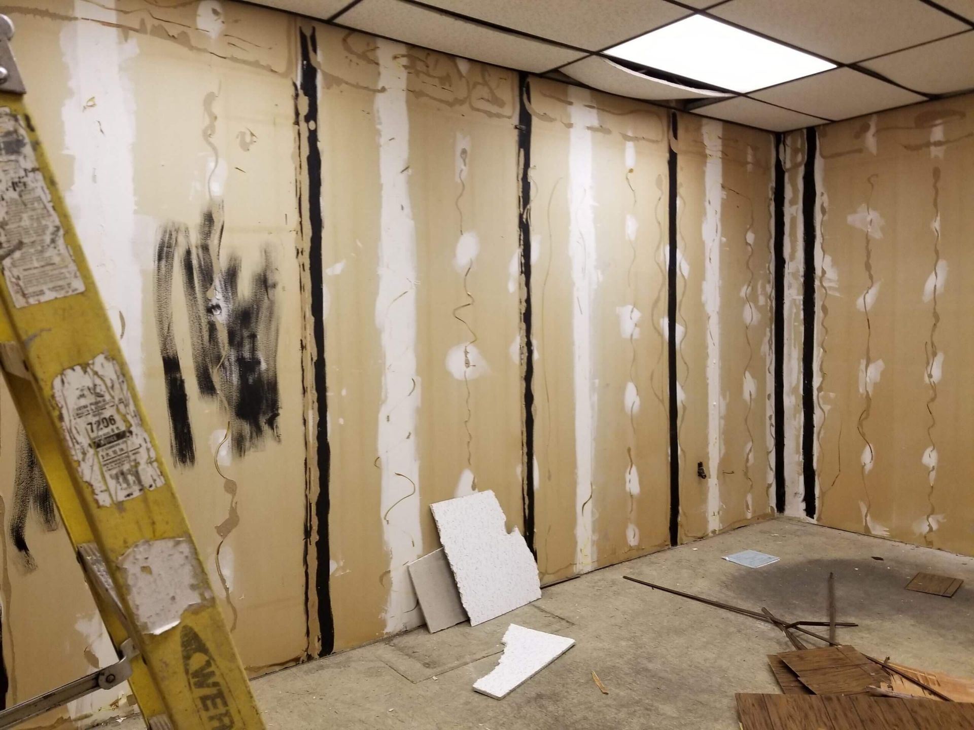 A room with a ladder and a lot of cardboard walls.