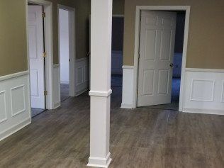 A large empty room with hardwood floors and white trim.