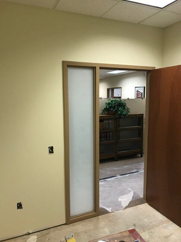 A room with a sliding glass door leading to another room.