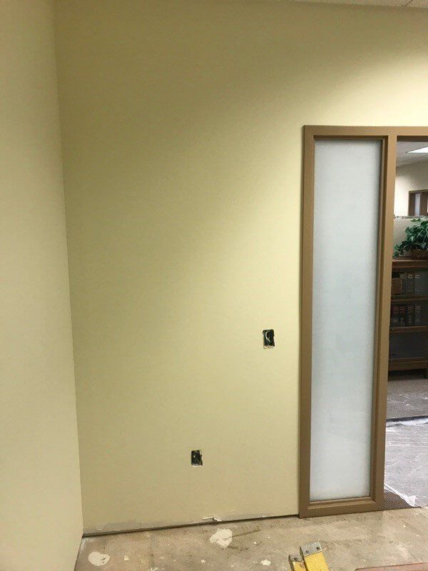 A room with yellow walls and a sliding glass door.