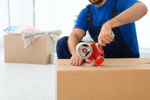 Mover Adding Tape To Moving Box — Furniture Removals in Dubbo, NSW