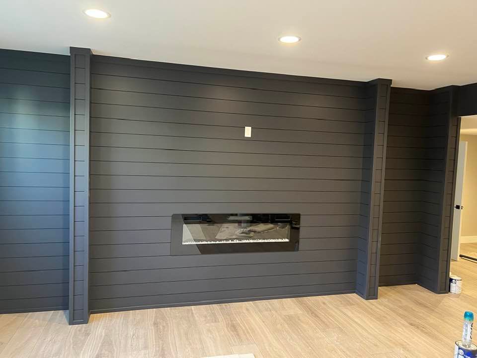 A living room with a fireplace in the middle of the wall.
