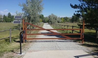 A wooden gate on the side of a dirt road