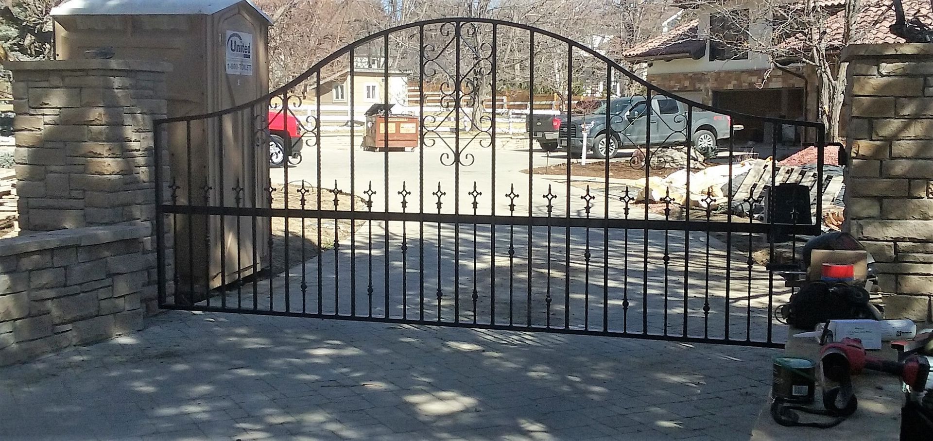 A motorcycle is parked in front of a wrought iron gate