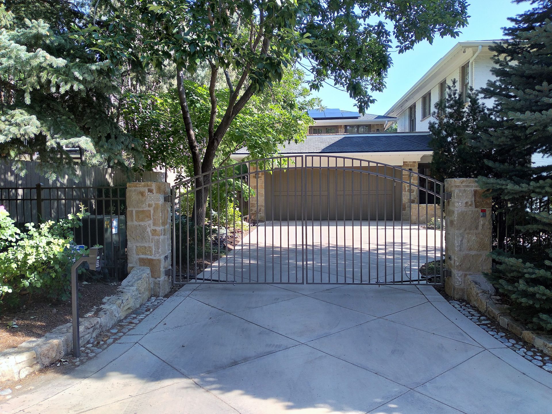 A driveway with a gate leading to a house