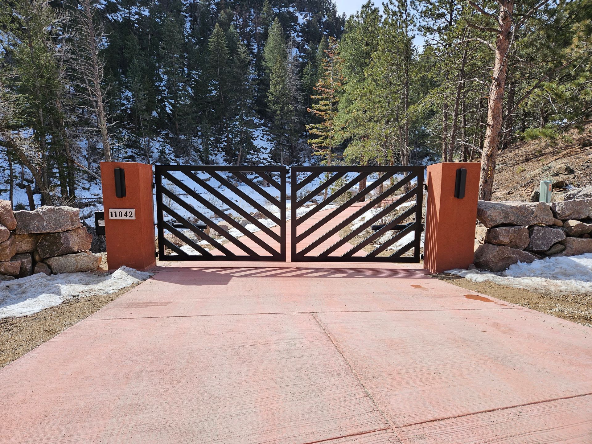A concrete driveway with a metal gate in the middle of it