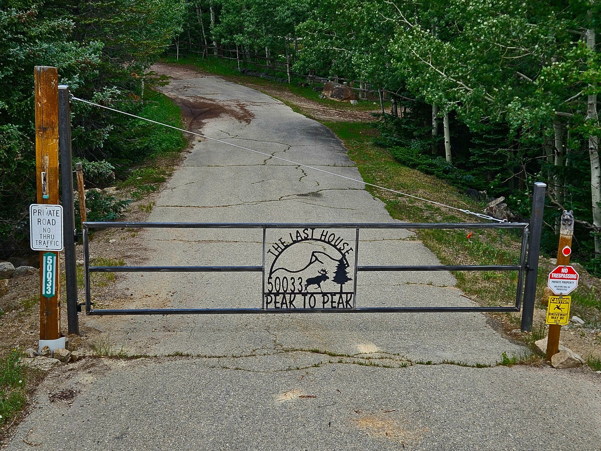 A gate on the side of a road with a sign on it that says home sweet home.
