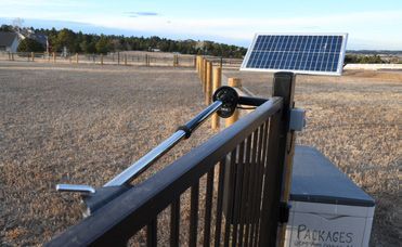 A solar panel is sitting on top of a wooden gate.