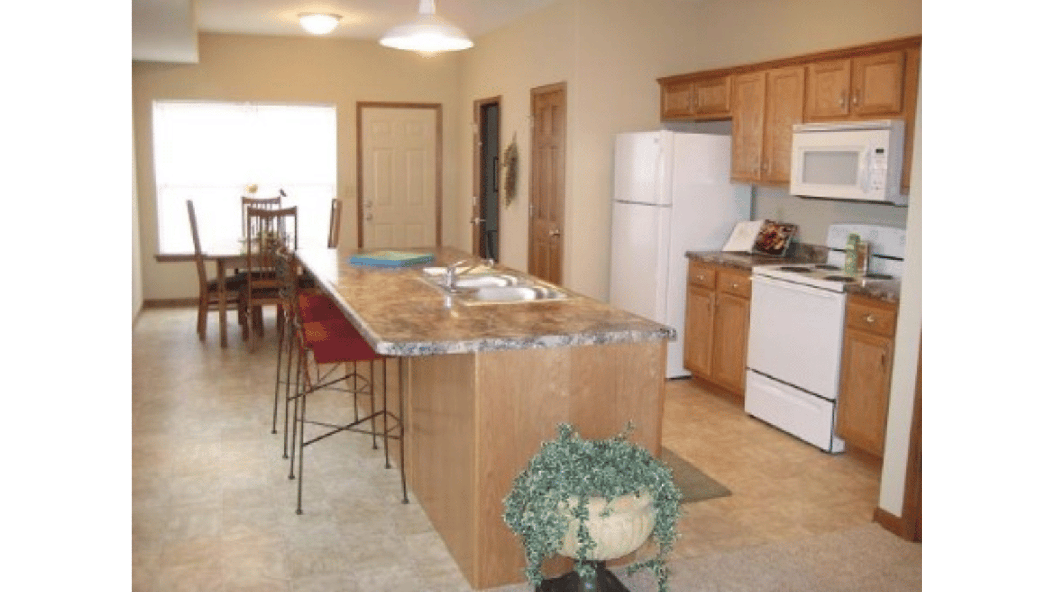 A kitchen with a large island and white appliances