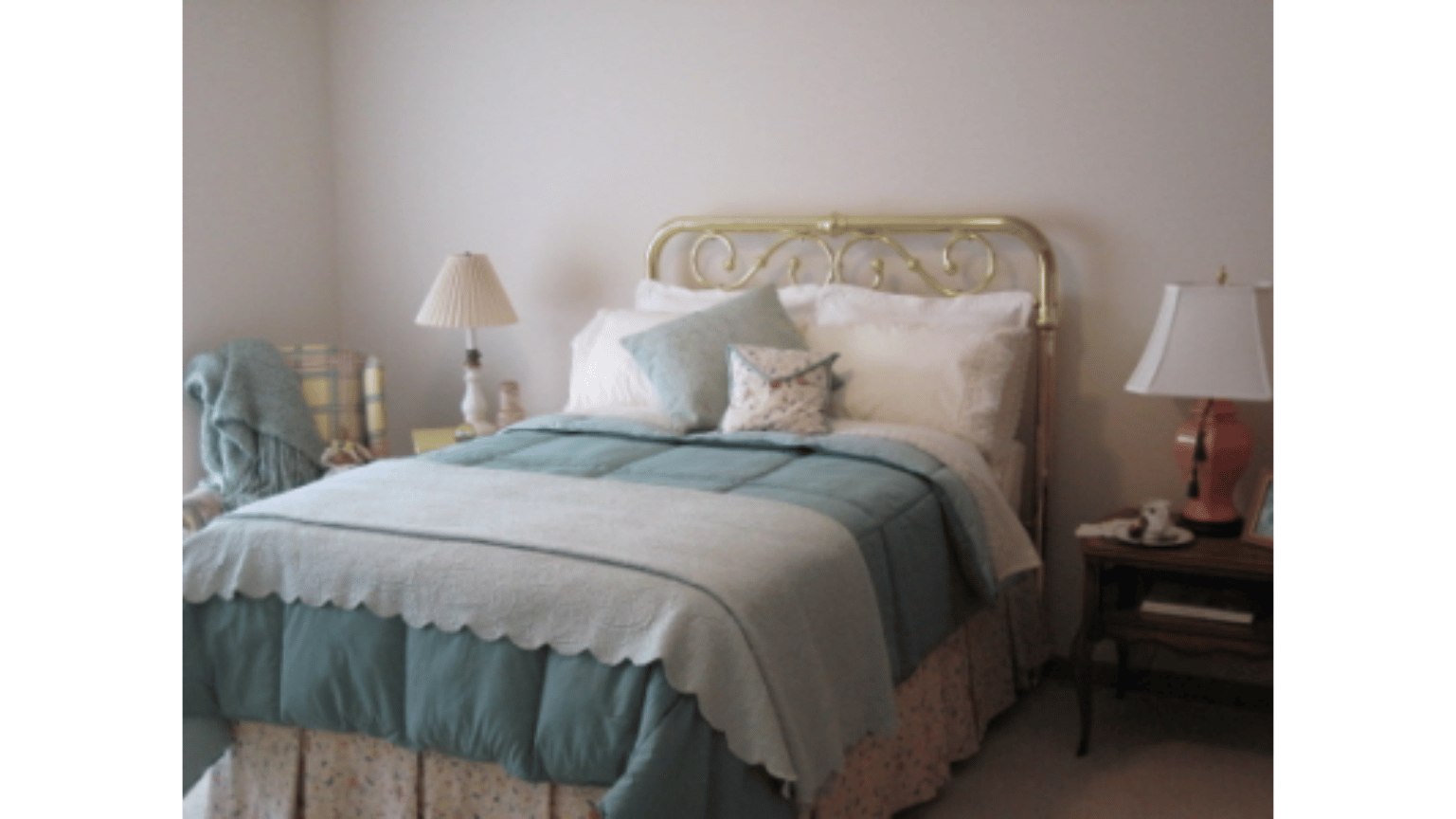 A bedroom with a bed and two lamps