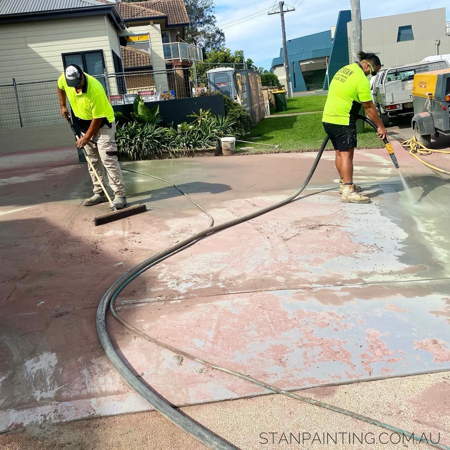 Two Workers in Safety Vests Cleaning a Red-Toned — Stan Painting Services In Newcastle, NSW