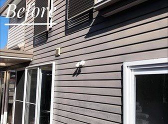 Exterior of a house with gray horizontal siding, white-framed windows, and dark shutters — Stan Painting Services In Thornton, NSW