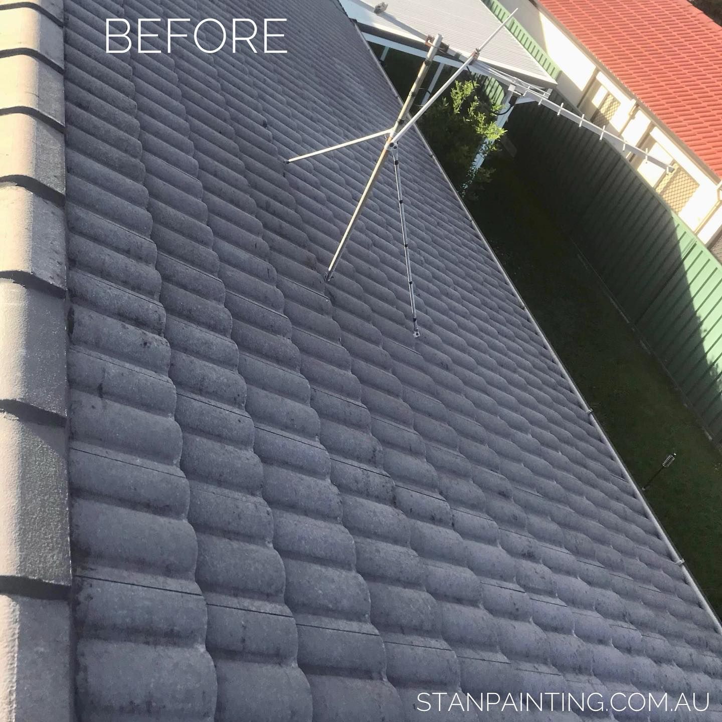 Gray Tiled Roof Before Cleaning with An Antenna on Top, Under a Bright Sky — Stan Painting Services In Belmont, NSW