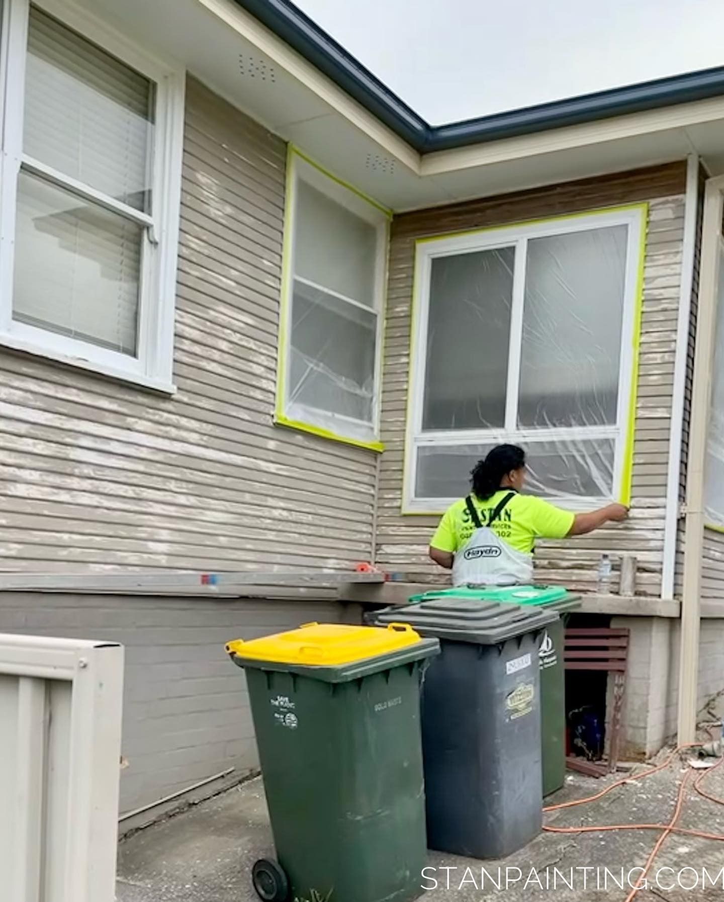 Person Taping Off Windows of A House Prior to Painting — Stan Painting Services In Port Stephens, NSW