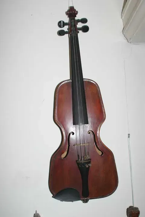 A Violin is Hanging on a White Wall