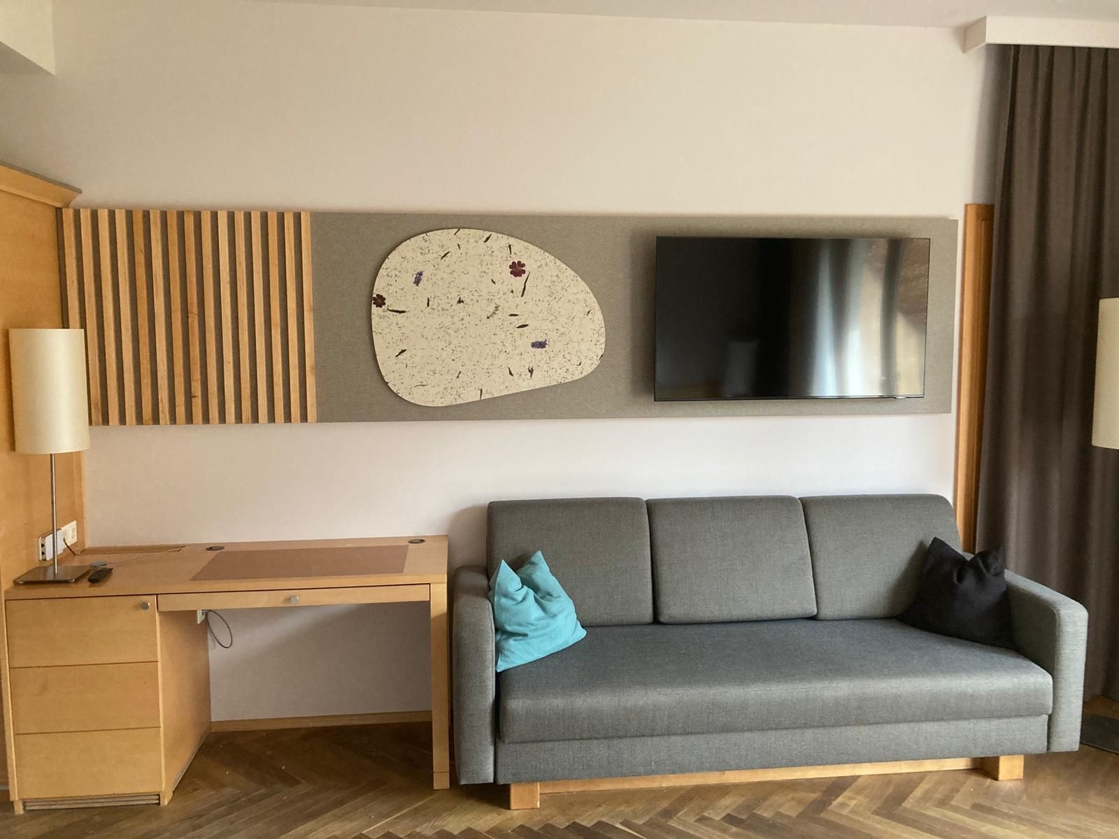 Ein Wohnzimmer mit Couch, Schreibtisch und Flachbildfernseher