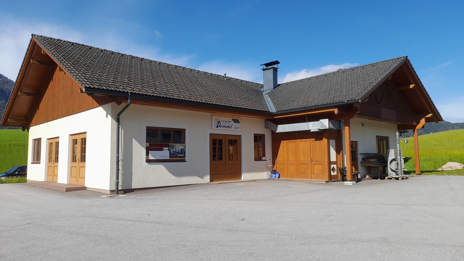 Ein kleines weißes Haus mit einem Holzdach