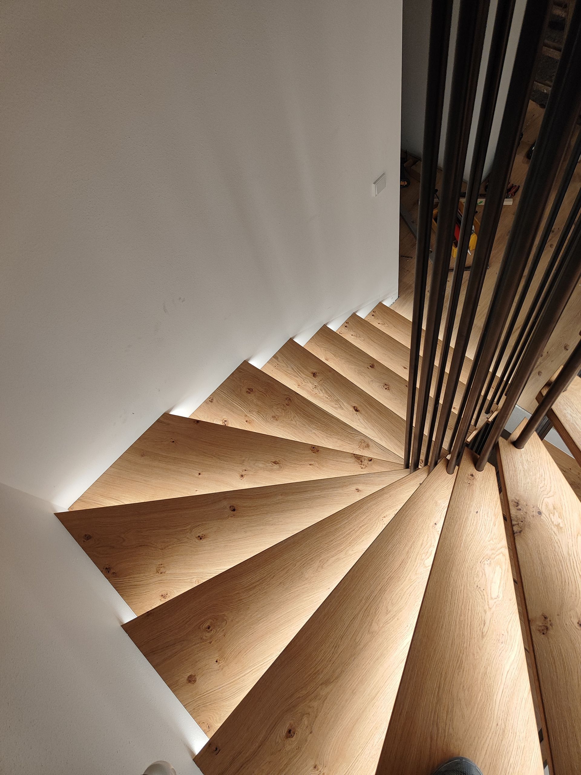 Eine Wendeltreppe mit Holzstufen und einem Metallgeländer