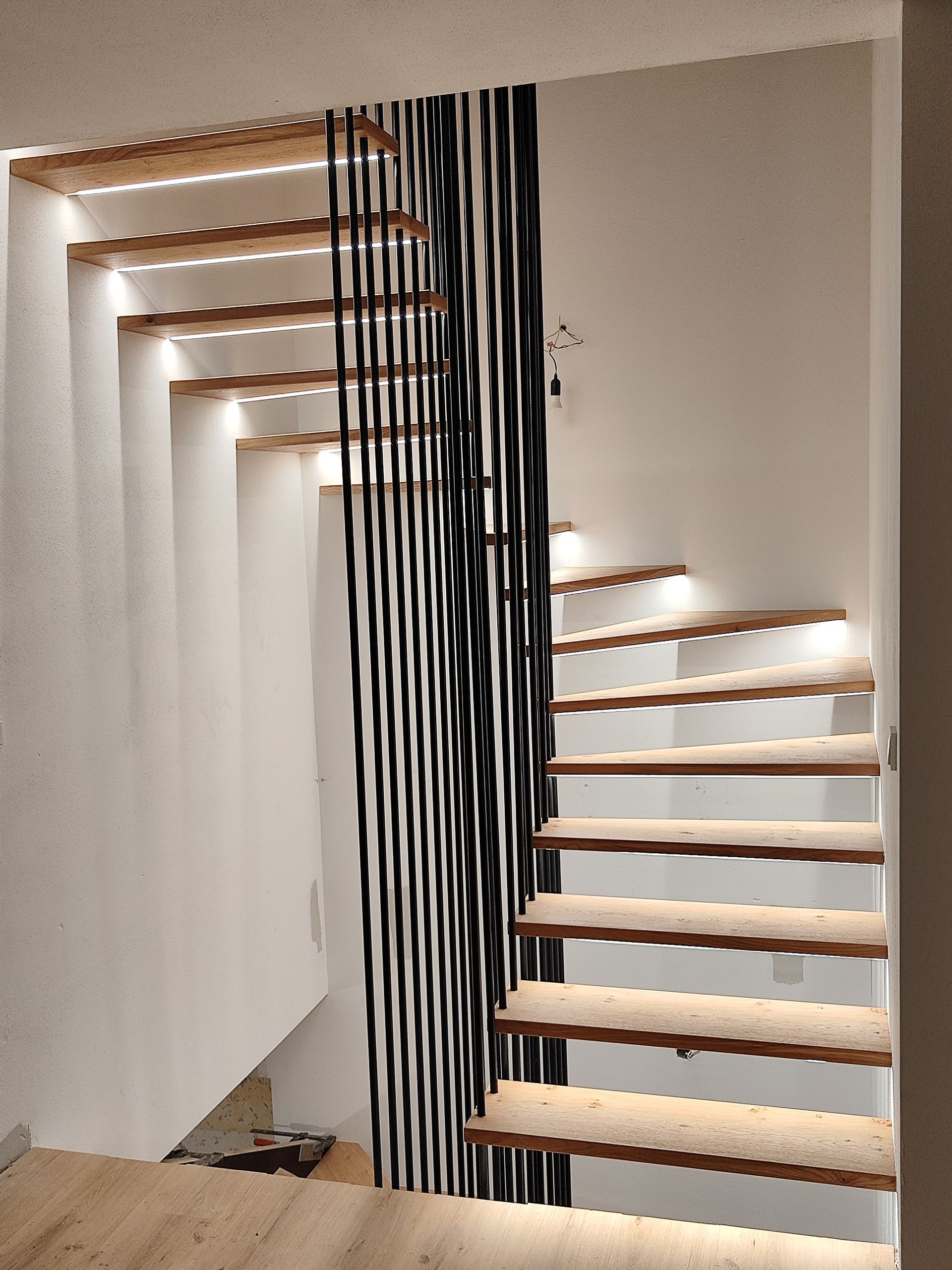 Eine Treppe mit einer schwarz-weiß gestreiften Wand dahinter