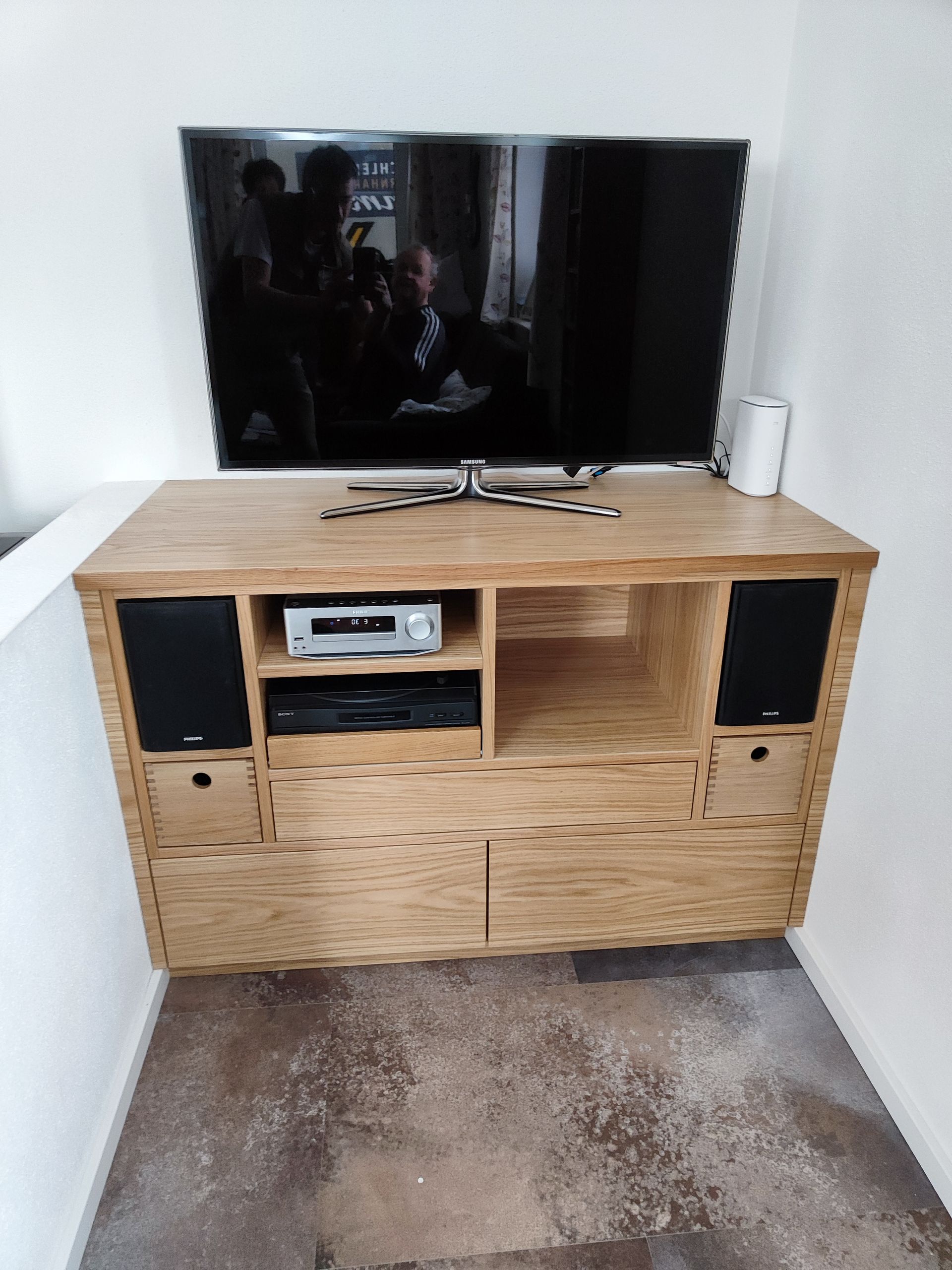 Auf einem hölzernen Entertainment-Center steht ein Flachbildfernseher.