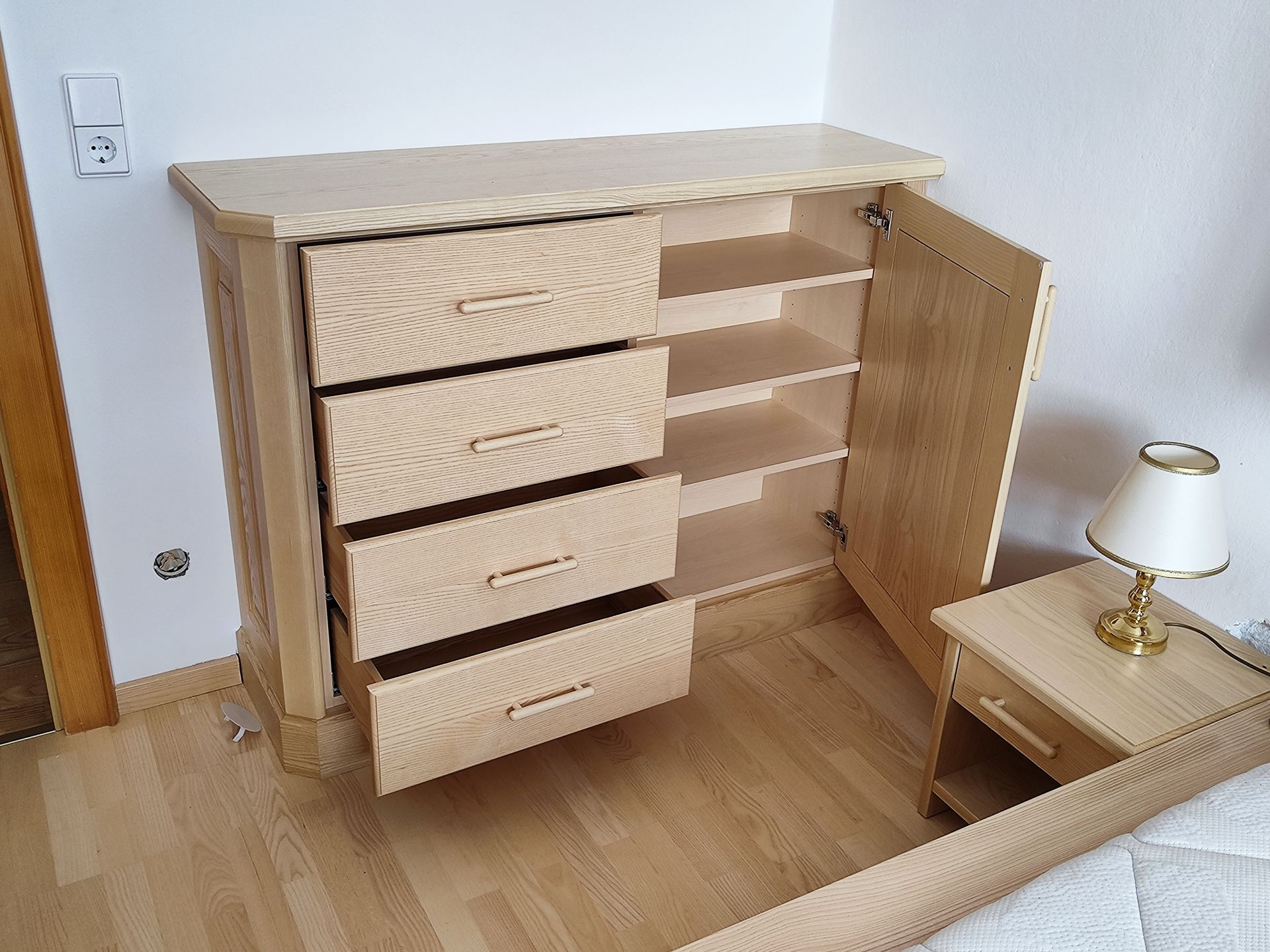 Ein Schlafzimmer mit Kommode, Nachttisch und Lampe.