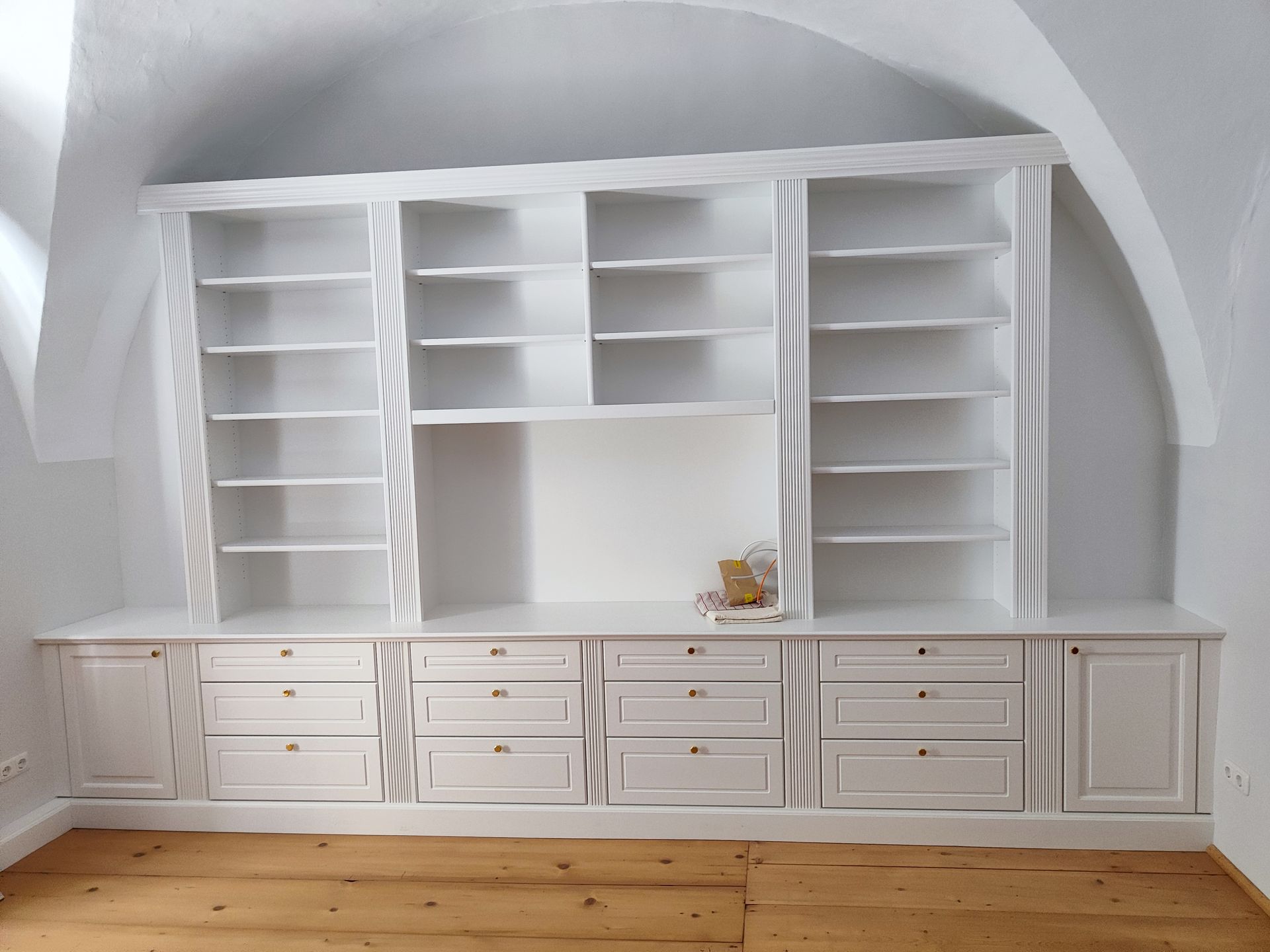 Ein Raum mit vielen weißen Regalen und Schubladen