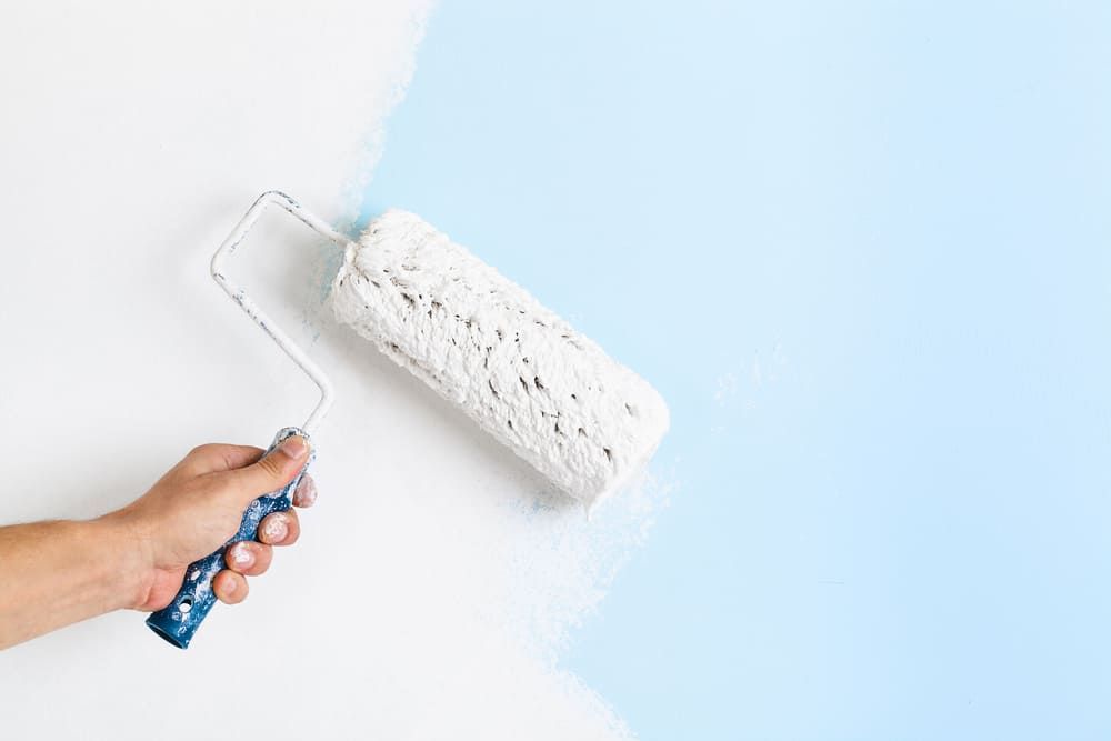 A Person Is Painting A Wall With A Paint Roller — Ballina Painting Service In Ballina, NSW