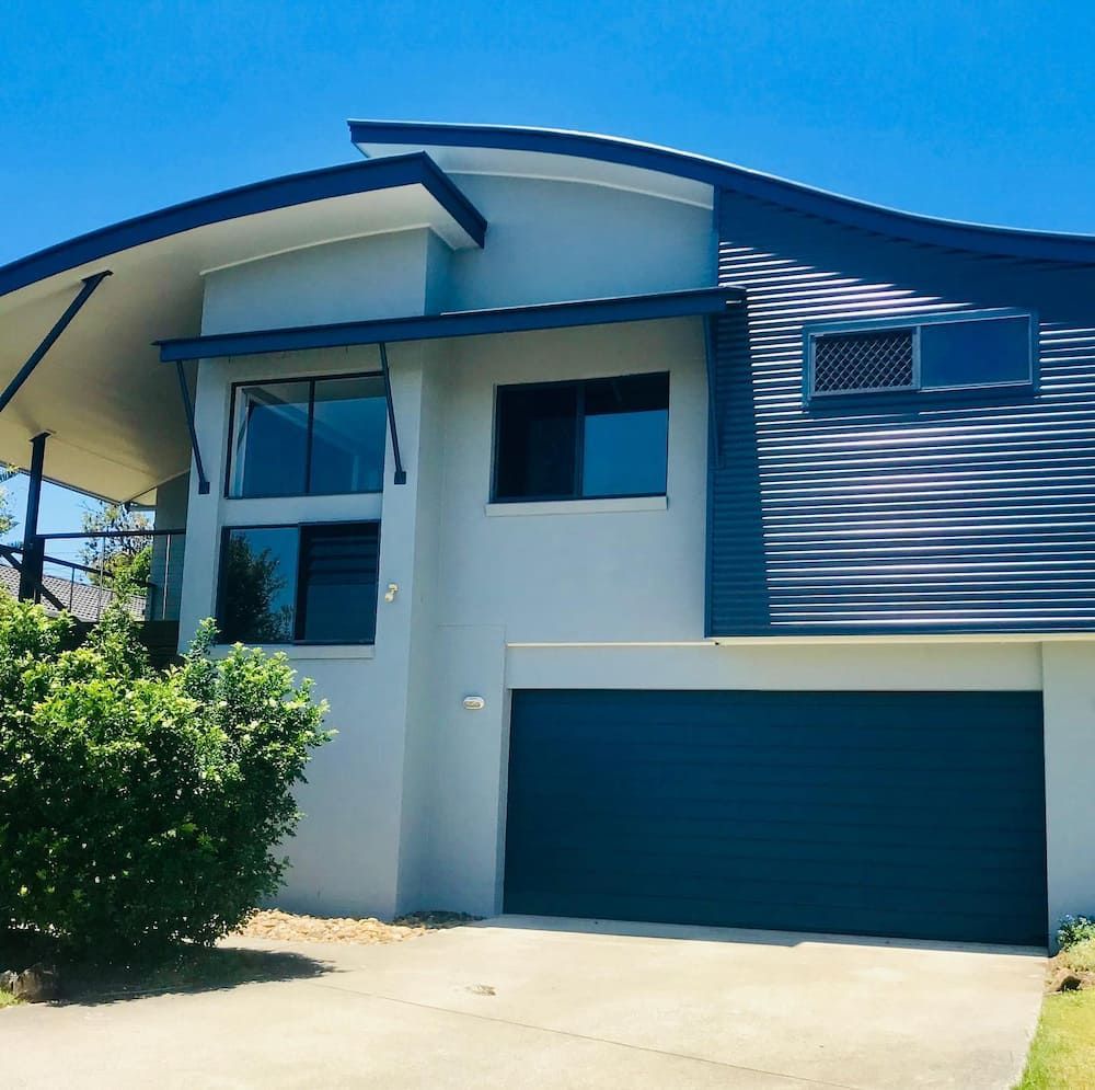 A Large White House With A Blue Garage Door — Ballina Painting Service In Ballina, NSW
