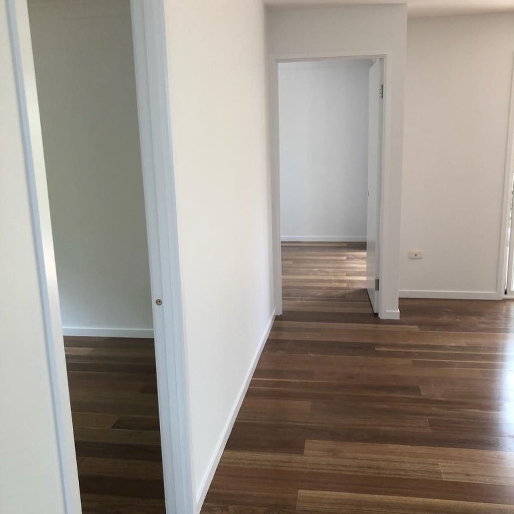 An Empty Hallway With Hardwood Floors And White Walls — Ballina Painting Service In Ballina, NSW
