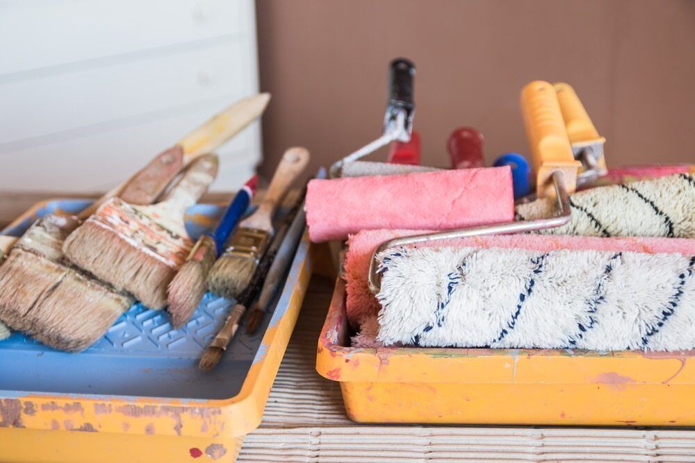 A Tray Of Paint Rollers And Brushes On A Table — Ballina Painting Service In Lennox Head, NSW