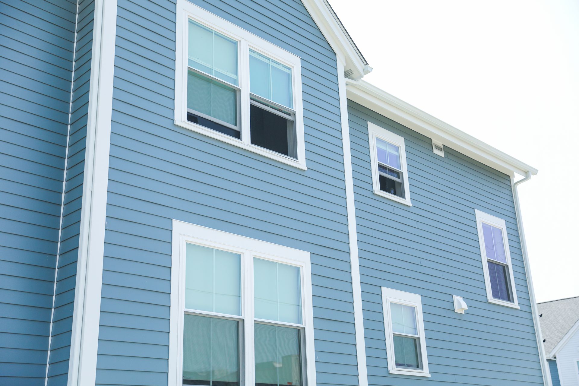 A blue house with white trim and a lot of windows
