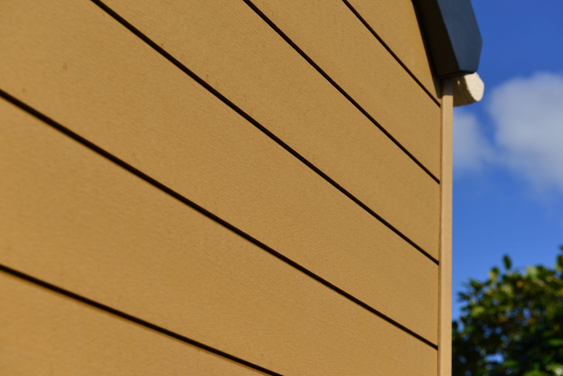 A close up of a yellow house with a blue sky in the background