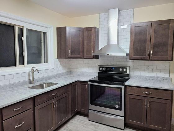 A kitchen with stainless steel appliances and wooden cabinets.